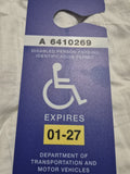 Blue disabled person parking permit card on a textured surface FL