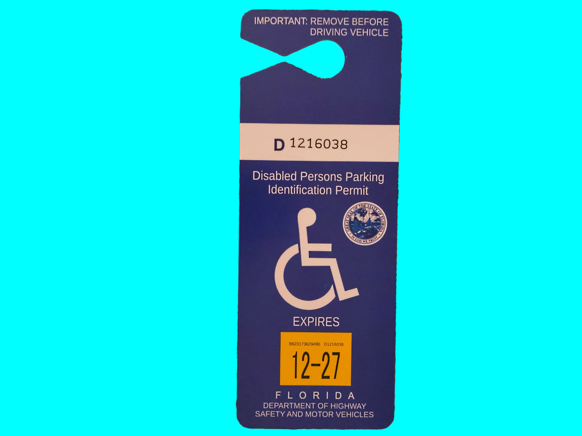 A blue Florida disabled person's parking identification permit card with a yellow expiration date sticker